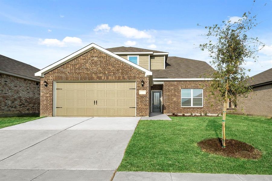 View of front of property featuring a garage and a front yard