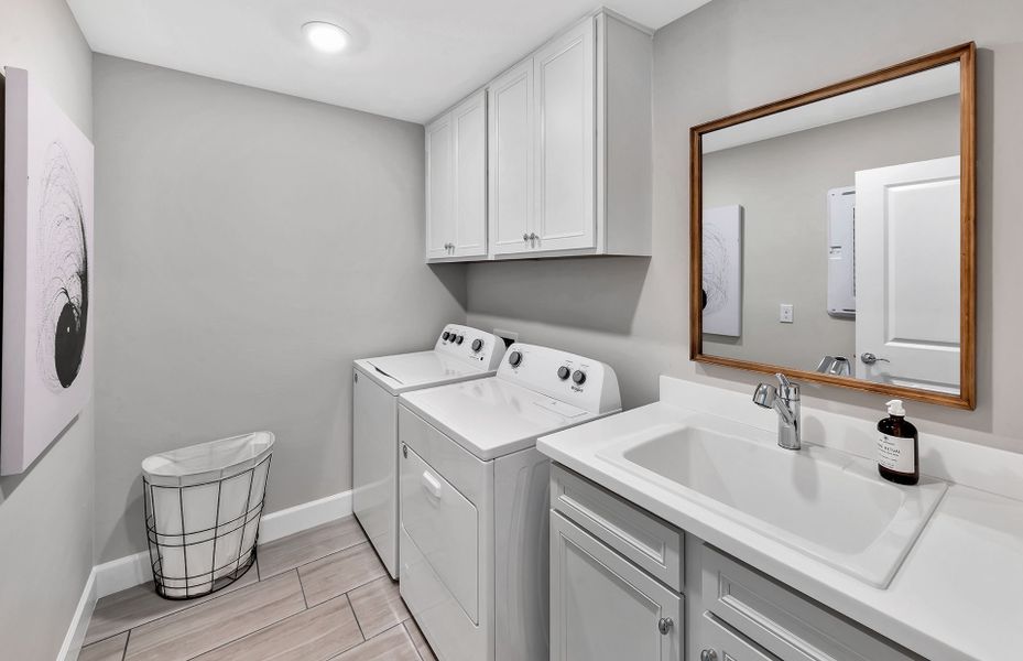 Laundry room with utility sink and cabinets for extra storage
