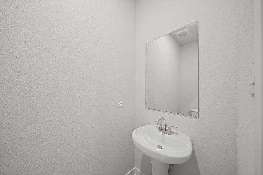 A bathroom with a mirror and sink.