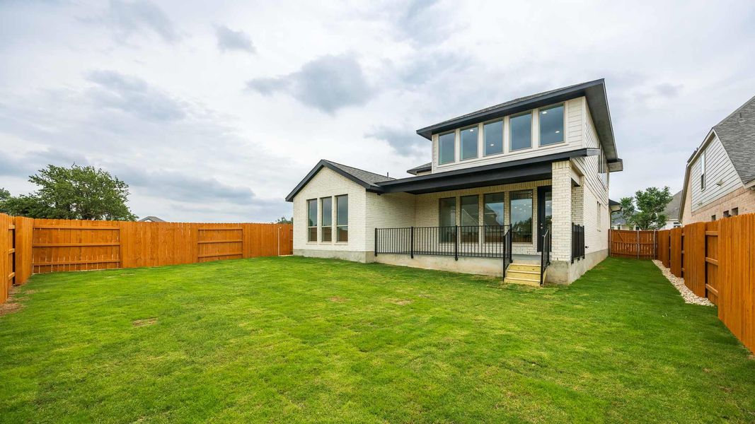 Back of property featuring a yard, brick siding, and a fenced backyard Back of property featuring a yard, brick siding, and a fenced backyard