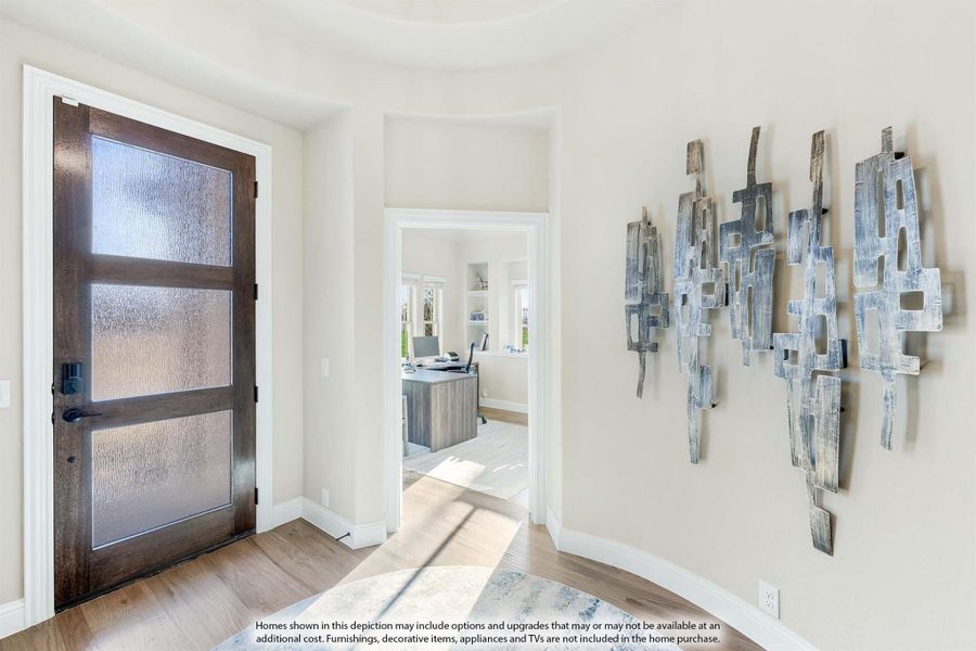 Foyer with dark wood front door featuring frosted glass panels and light hardwood floors leading to a home office Foyer with dark wood front door featuring frosted glass panels and light hardwood floors leading to a home office