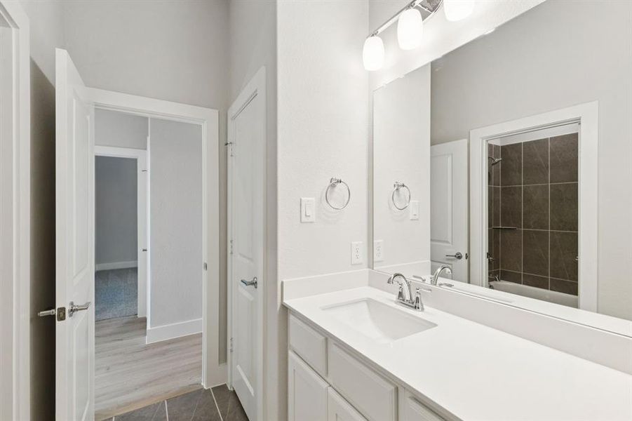 Full bathroom featuring vanity, dark tile patterned floors, and shower / tub combination