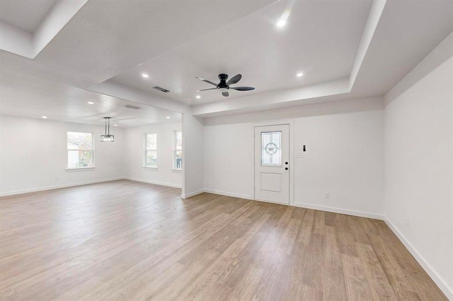 Entryway featuring a raised ceiling, light hardwood / wood-style flooring, and ceiling fan