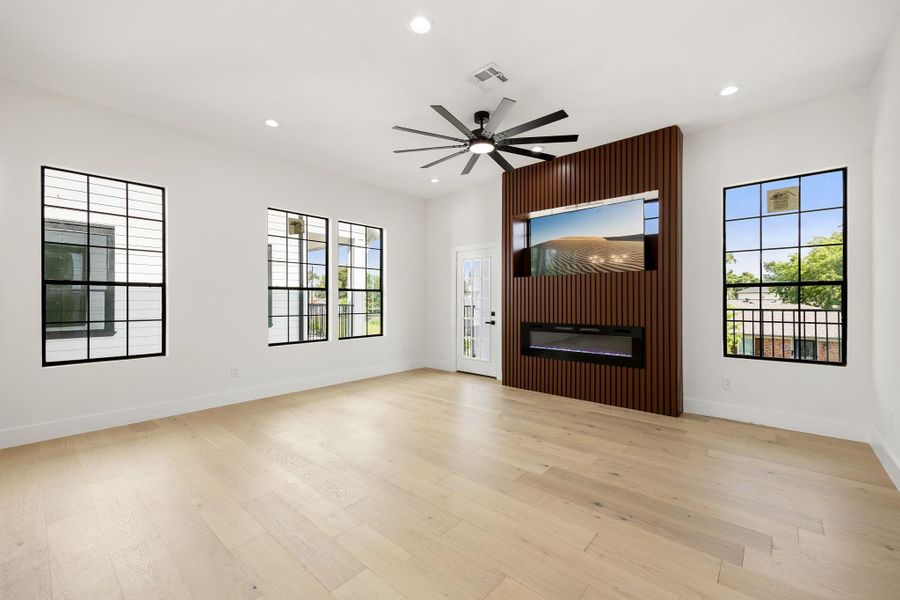 A view from the kitchen highlights the retractable TV and electric fireplace, with convenient access to the balcony.
