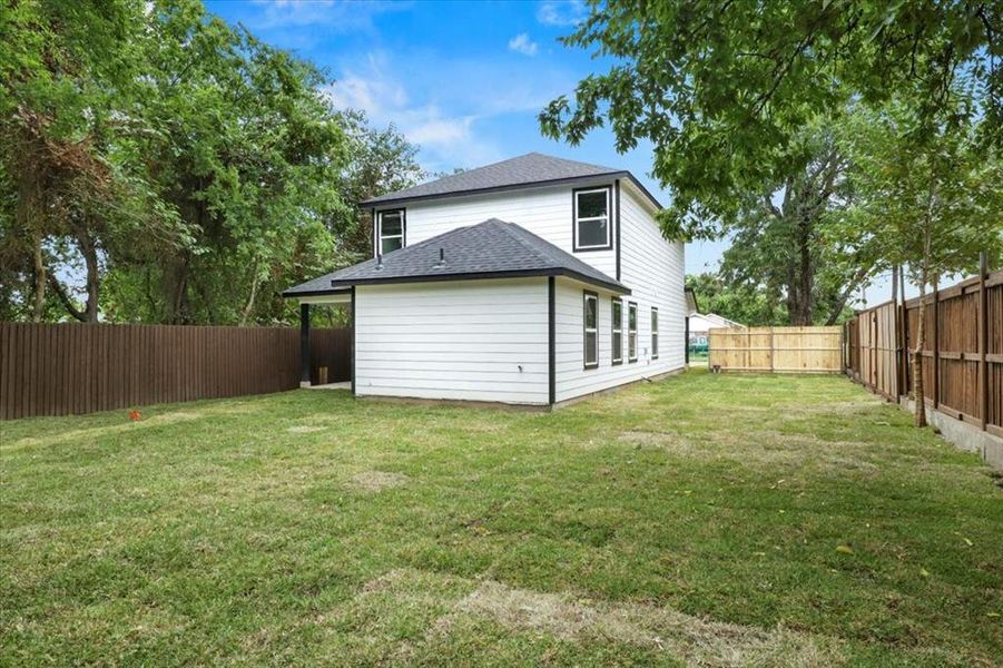 Rear view of house featuring a lawn