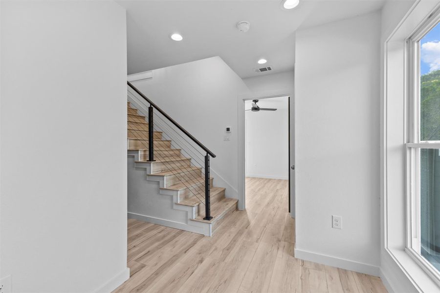 Stairs with wood finished floors, a ceiling fan, and recessed lighting