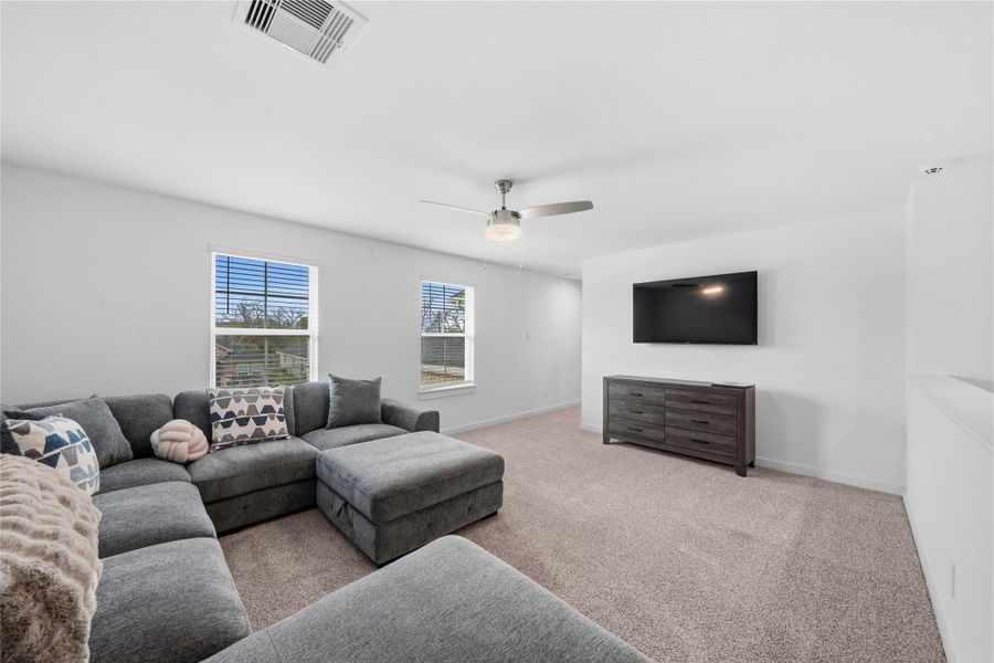 A spacious second-floor game room features plush carpeting and two large windows that bring in natural light, creating a comfortable and versatile retreat. A spacious second-floor game room features plush carpeting and two large windows that bring in natural light, creating a comfortable and versatile retreat.
