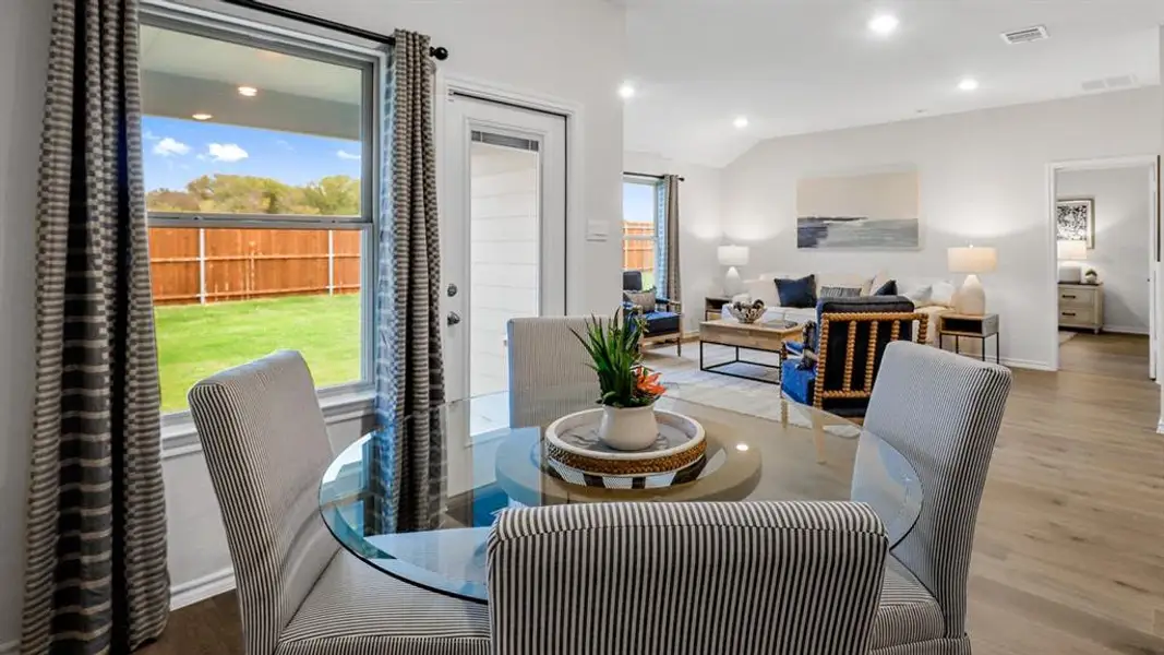 Dining room featuring wood finished floors, recessed lighting, and vaulted ceiling Dining room featuring wood finished floors, recessed lighting, and vaulted ceiling