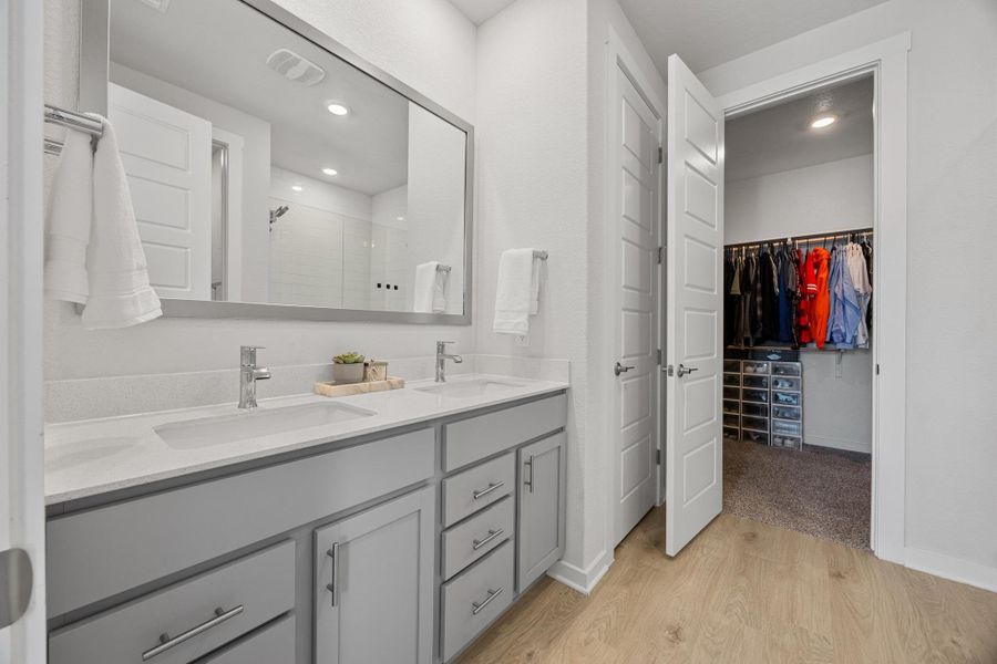 Primary Bathroom with double vanity and a walk in shower.