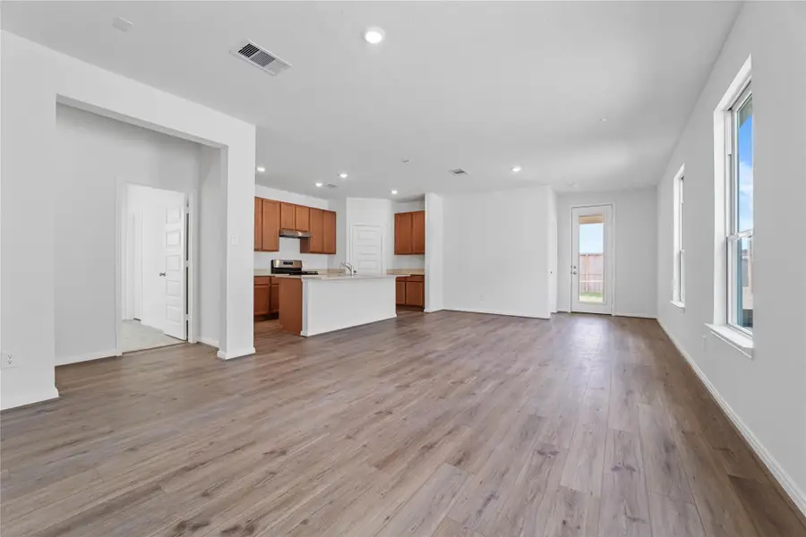 Bring family and friends together in this beautiful Great Room! It features high ceilings, recessed lighting, custom paint, stunning vinyl plank flooring, and large windows that fill the space with natural light all day long.