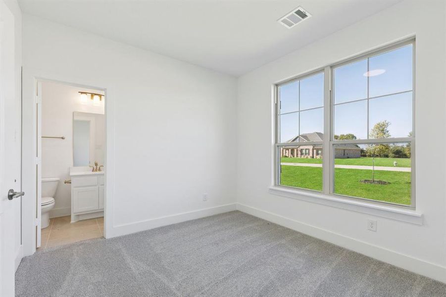 Unfurnished bedroom with light colored carpet and ensuite bath