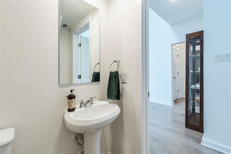 Powder room located between entry and living space perfect for guests.