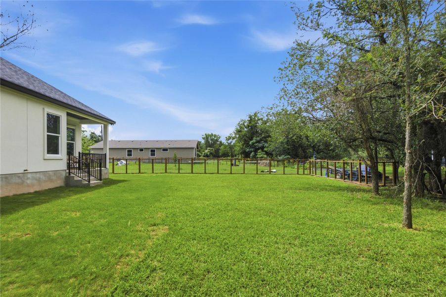 A verdant backyard with a freshly mown lawn, perfect for outdoor activities and relaxation.