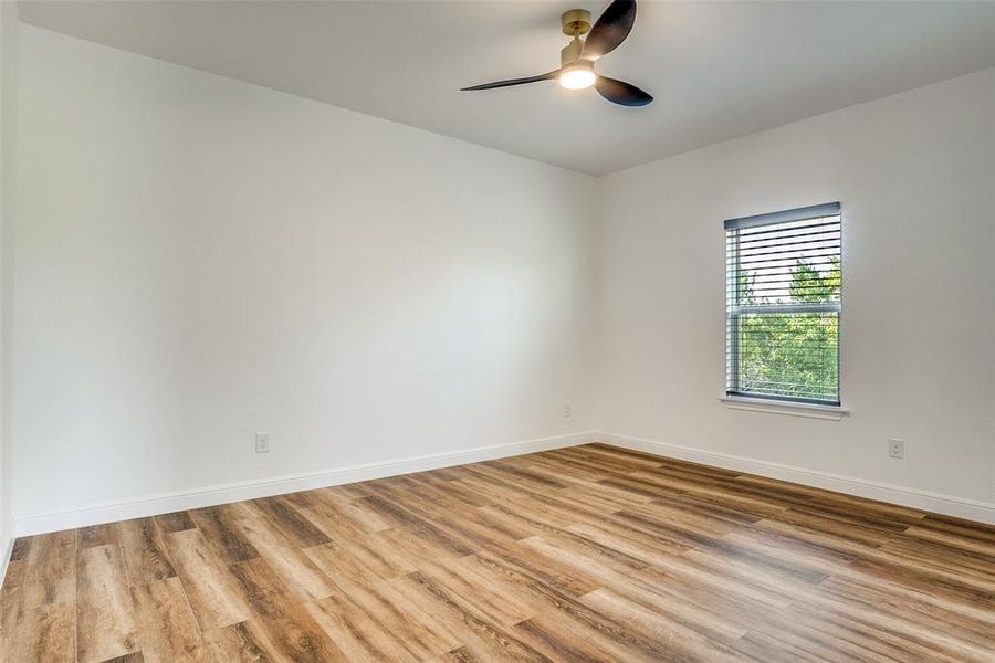 Unfurnished room featuring wood finished floors and ceiling fan