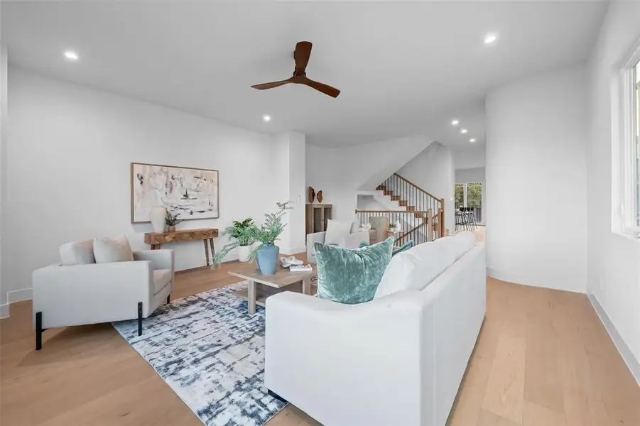 Living area featuring recessed lighting, light wood finished floors, ceiling fan, and stairway