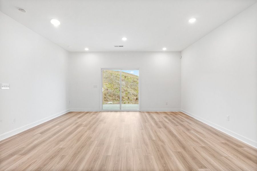 A room with a wood floor and a window.