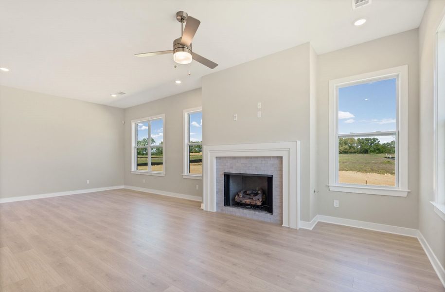 Unfurnished living room with recessed lighting, a fireplace, a ceiling fan, and light wood-style flooring