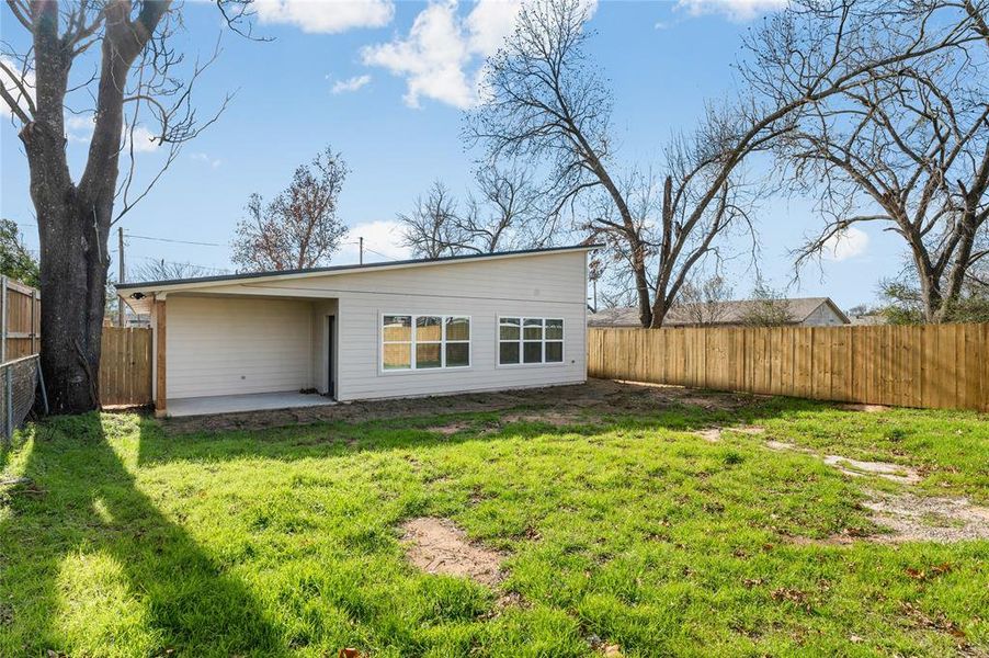 Rear view of house with a lawn and a patio area