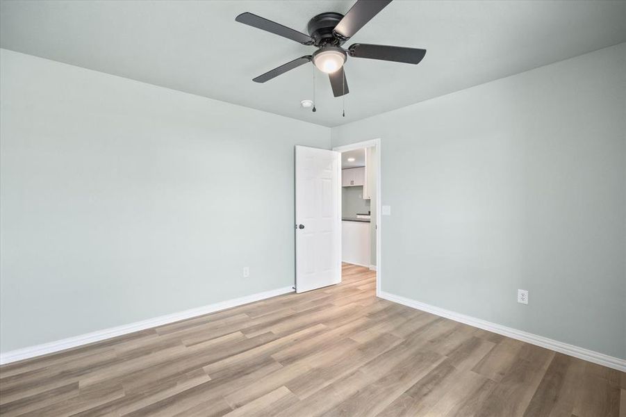 Empty room with light hardwood / wood-style flooring and ceiling fan