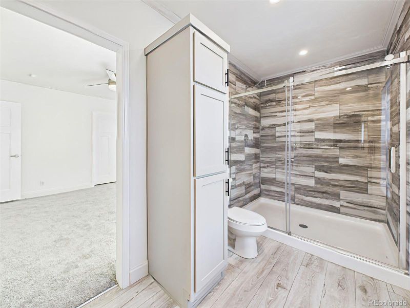 Spacious walk-in shower with full tile surround and built-in linen cabinetry. Spacious walk-in shower with full tile surround and built-in linen cabinetry.