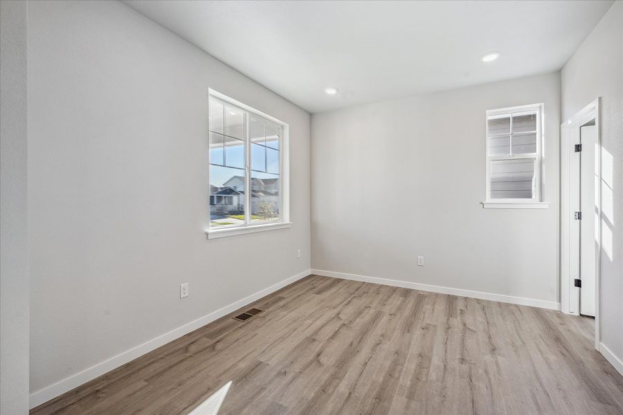 A room with a wood floor and a window. A room with a wood floor and a window.