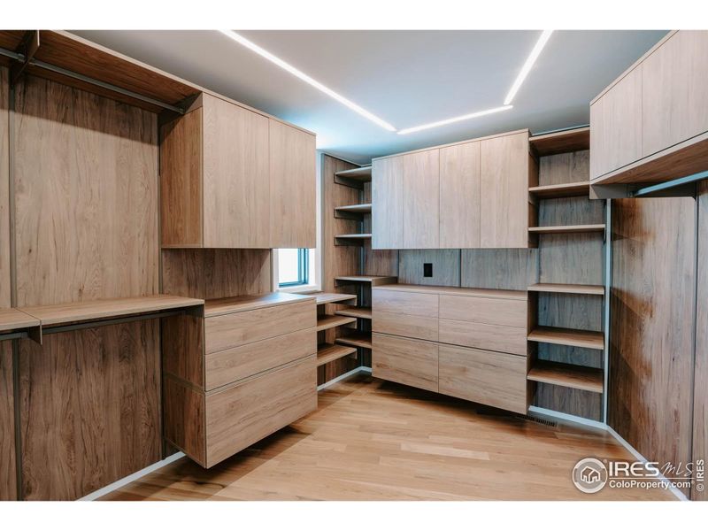 Custom touch open/close cabinetry in the primary closet with linear channel lighting.