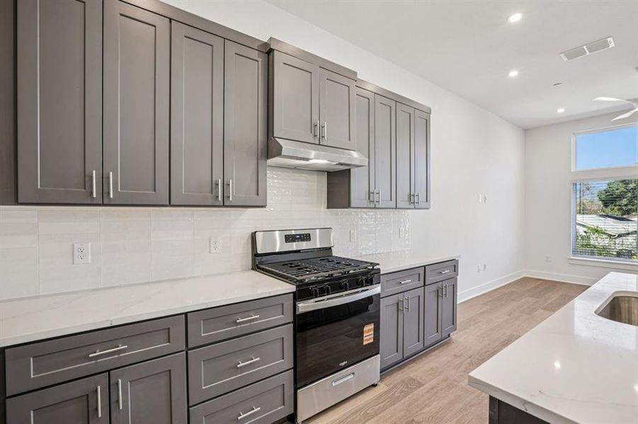 The kitchen features a center island, quartz counters and SS appliances. (Sample photoof finishes and layout)