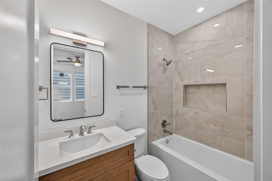 secondary bathroom with custom cabinetry and beautiful tile that extend to the ceiling