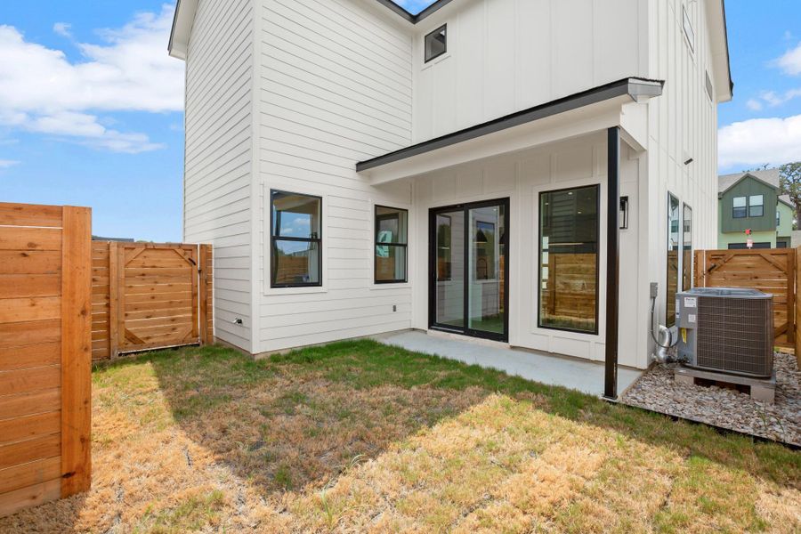 Back of house featuring a fenced backyard, board and batten siding, and a patio