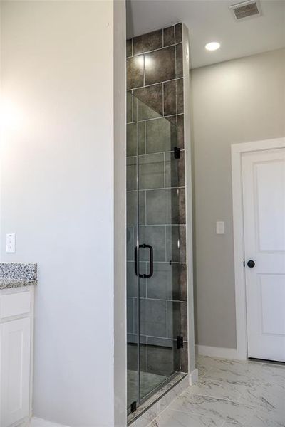 Full bathroom featuring marble look tile flooring, a stall shower, recessed lighting, and vanity