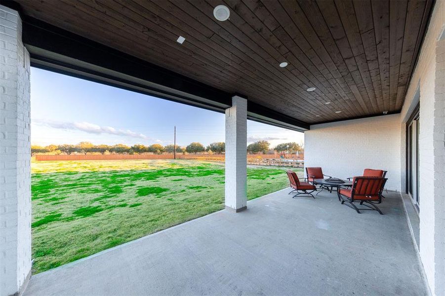 Outdoor living is elevated with an extended covered patio overlooking the one acre lot, a perfect spot for relaxation and entertainment.