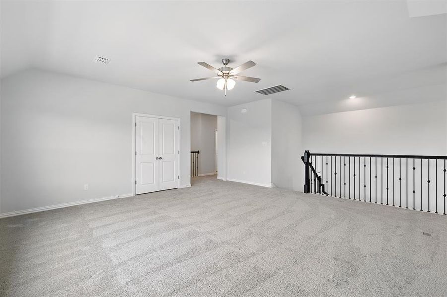 Spare room with a ceiling fan, carpet floors, baseboards, and vaulted ceiling Spare room with a ceiling fan, carpet floors, baseboards, and vaulted ceiling