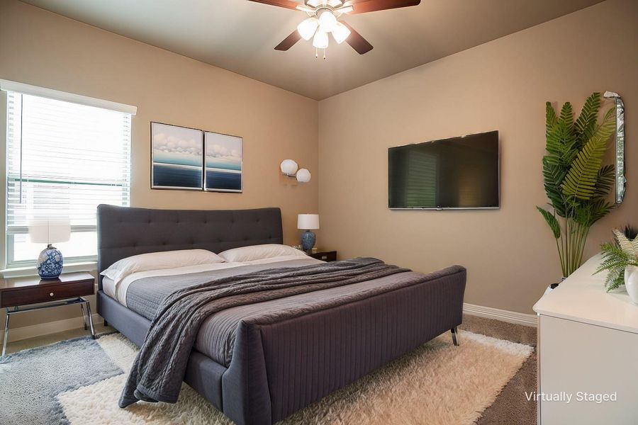 Bedroom with baseboards, light colored carpet, and ceiling fan
