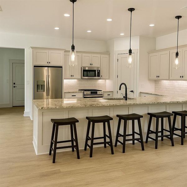 Kitchen with appliances with stainless steel finishes, light wood-style flooring, a kitchen breakfast bar, and recessed lighting