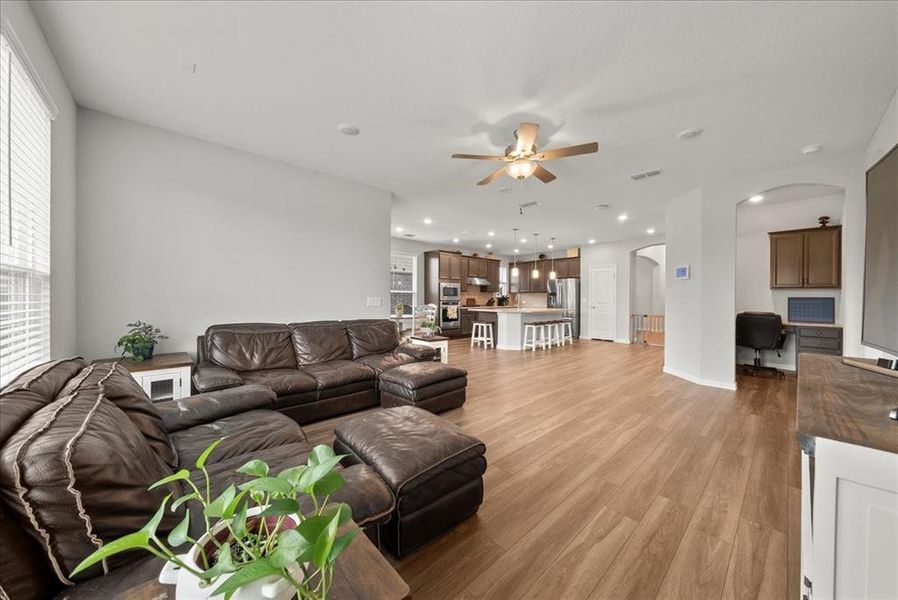 Living room with light hardwood / wood-style floors and ceiling fan