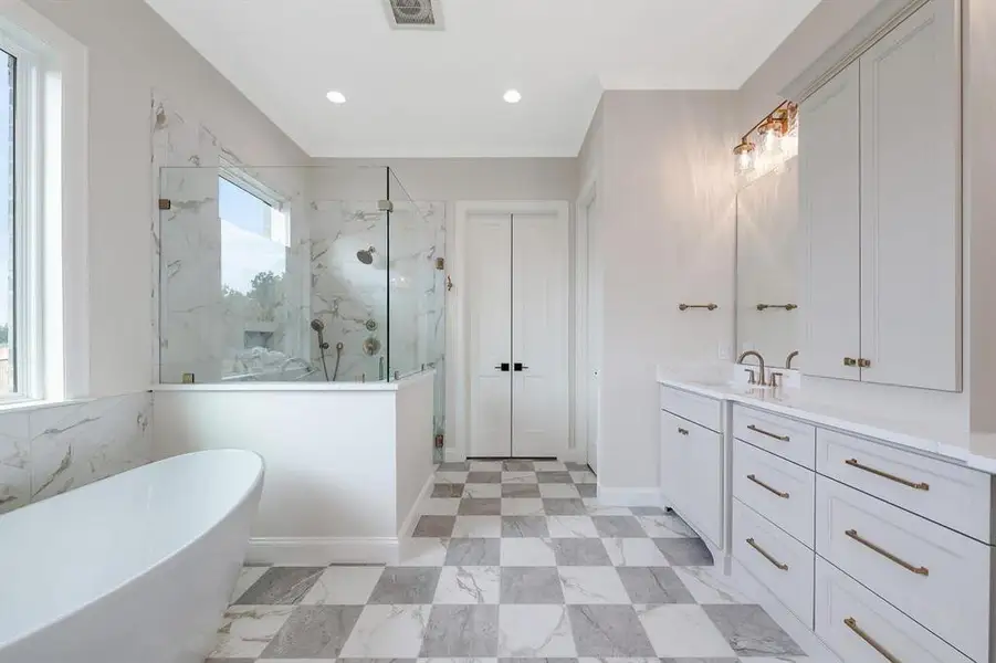 Full bathroom featuring a marble finish shower, a freestanding bath, vanity, and recessed lighting Full bathroom featuring a marble finish shower, a freestanding bath, vanity, and recessed lighting