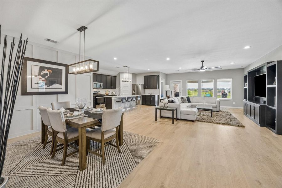 Great view of the dining room, kitchen, breakfast bar, and living room.  That  is a custom built-in entertainment center on the right.