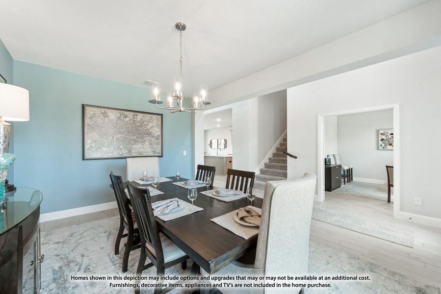Dining room with dark wood table, six chairs, chandelier, and blue accent wall