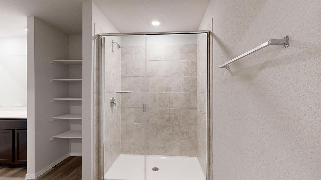 Full bath featuring vanity, a shower stall, and wood finished floors