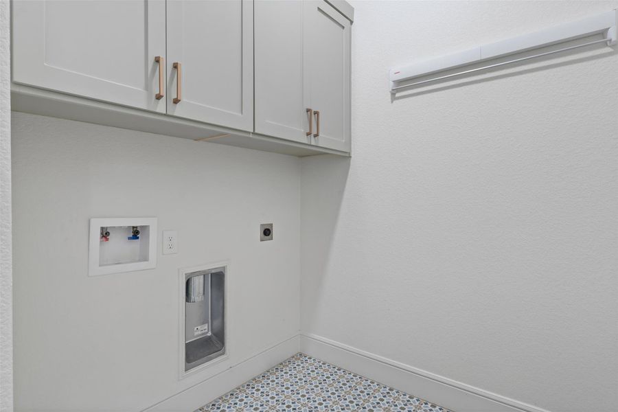 Washroom with baseboards, washer hookup, tile patterned floors, cabinet space, and electric dryer hookup