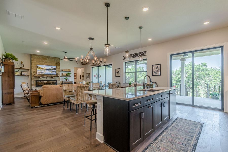 Kitchen featuring light wood-style flooring, light countertops, ceiling fan, recessed lighting, and a center island with sink