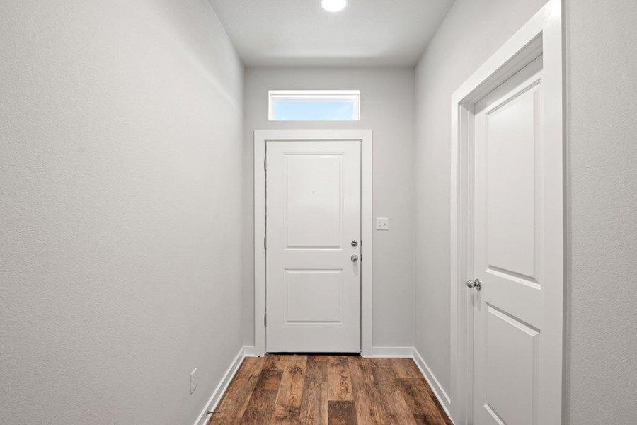 Doorway to outside with baseboards and wood finished floors