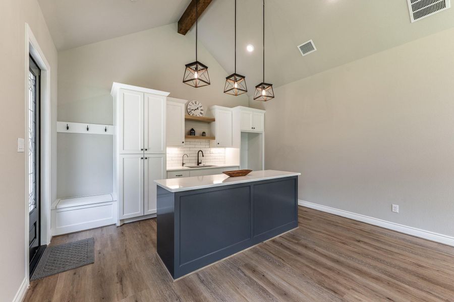Kitchenette with custom built-ins, sink, and room for refrigerator