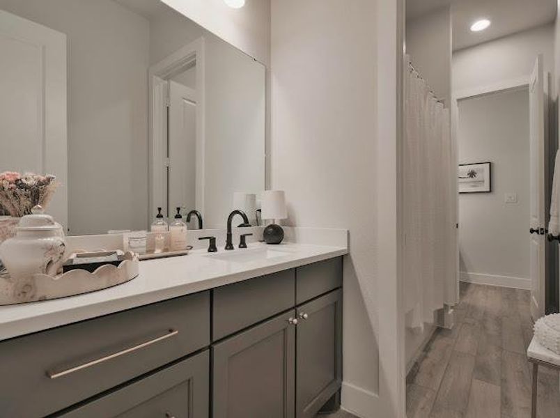 Full bath with vanity, light wood-style floors, and shower / tub combo with curtain Full bath with vanity, light wood-style floors, and shower / tub combo with curtain