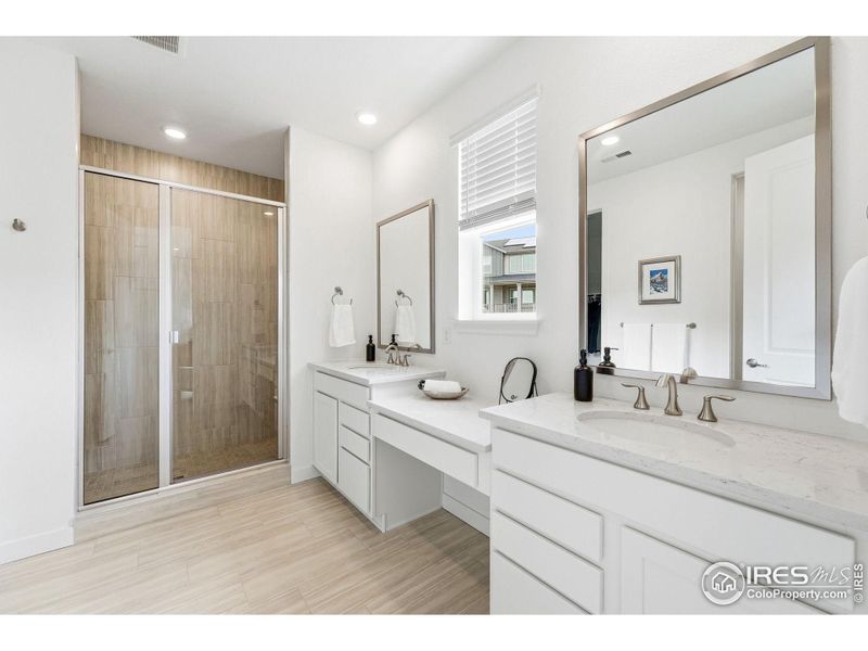 Primary bathroom with dual vanities and a spa-inspired layout.