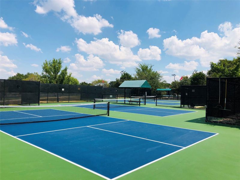 Sporting complex featuring multiple hard surface courts ready for play, under an open sky. Sporting complex featuring multiple hard surface courts ready for play, under an open sky.