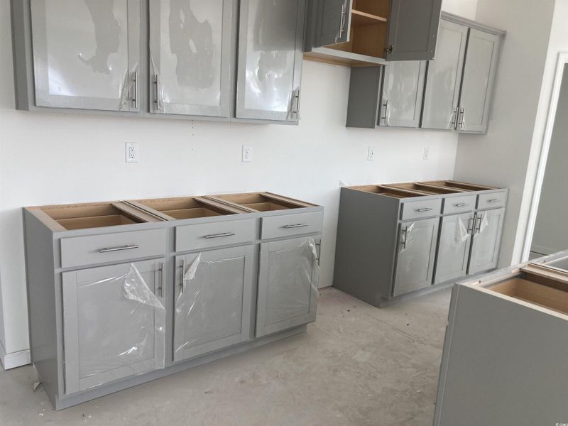 Kitchen featuring gray cabinetry and unfinished concrete floors