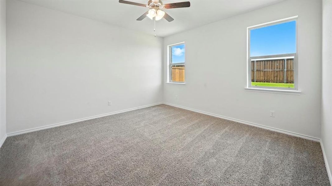Spacious room featuring gray carpeting, white baseboards, and bright white walls