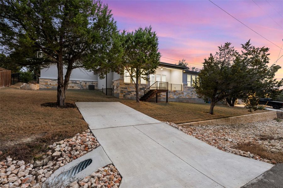Obstructed view of property featuring stone siding and stucco siding
