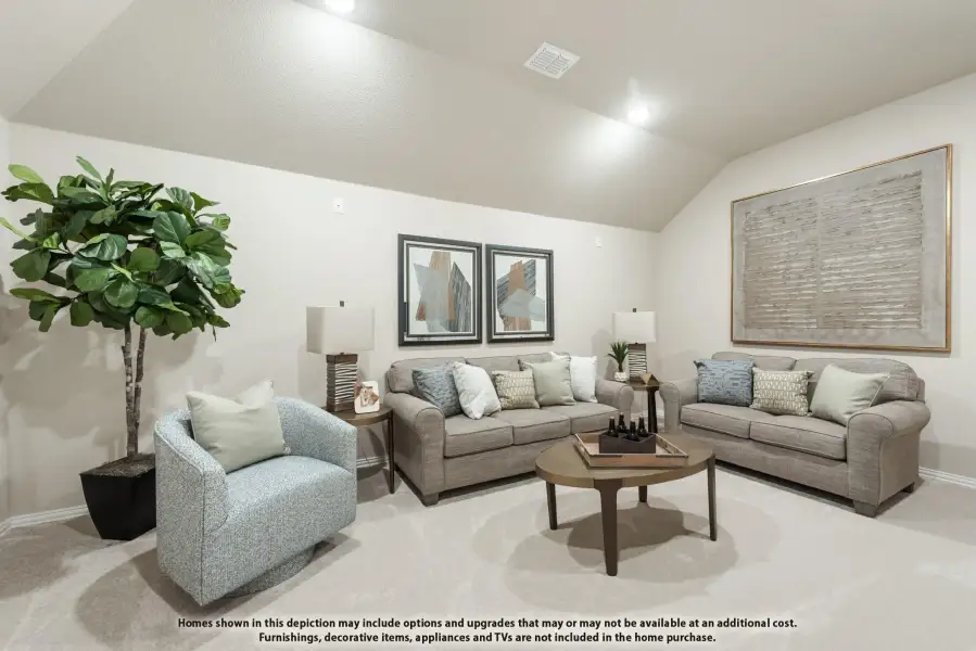 Living room with vaulted ceiling, gray sofas, accent chair, and round coffee table on carpet Living room with vaulted ceiling, gray sofas, accent chair, and round coffee table on carpet